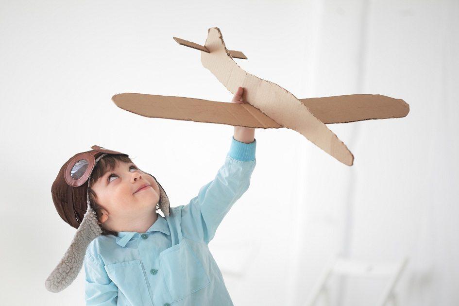 Natureza, garoto brincando com um avião de brinquedo.