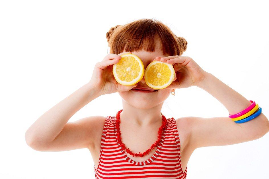 Natureza, imagem de uma garota segurando duas metades de uma laranja.