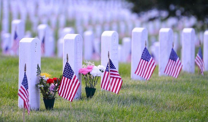 cemitério grama cruzes brancas com bandeira dos estados unidos e vasos de flores
