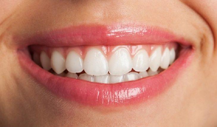 Na imagem, uma mulher sorri mostrando os dentes brancos e alinhados. Eficácia da camisinha.