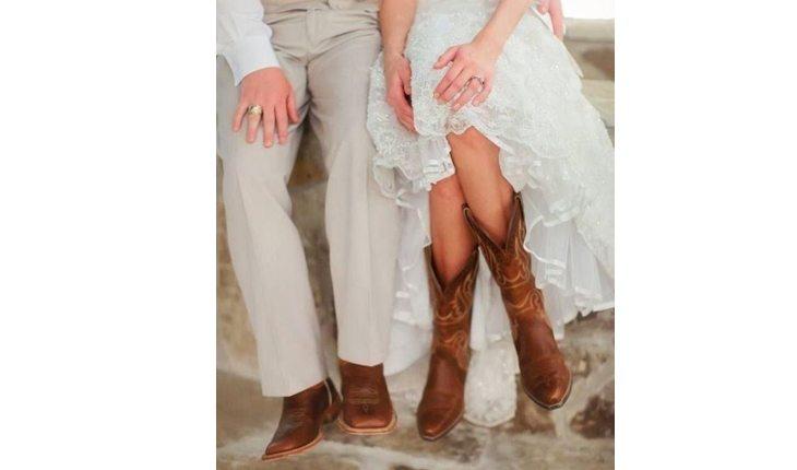 Na foto há um casal usando bota estilo cowboy no dia do casamento.