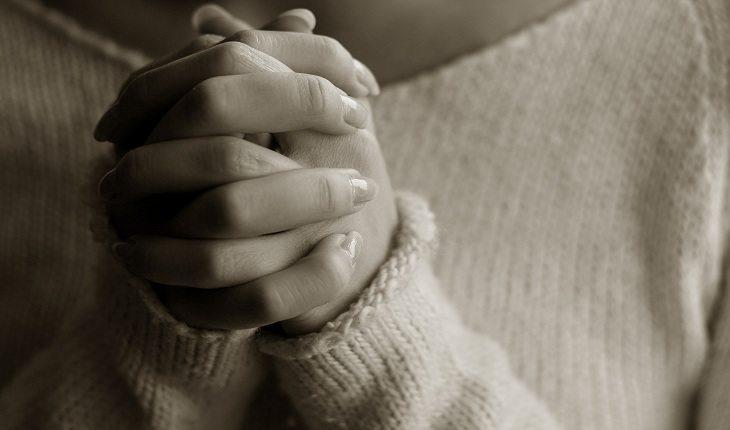 mãos femininas em posição de oração