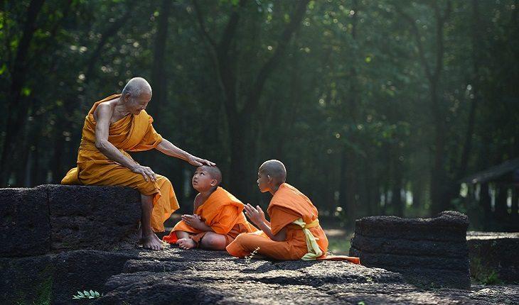 Homem de idade, abençoando as crianças, monges