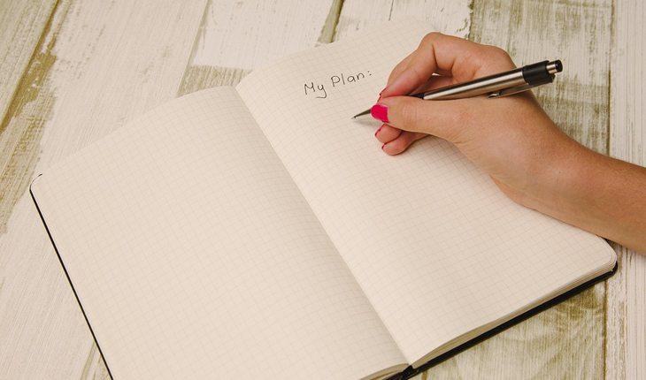 Espiritualidade. Na foto, uma mulher escrevendo em um caderno os planos para a vida