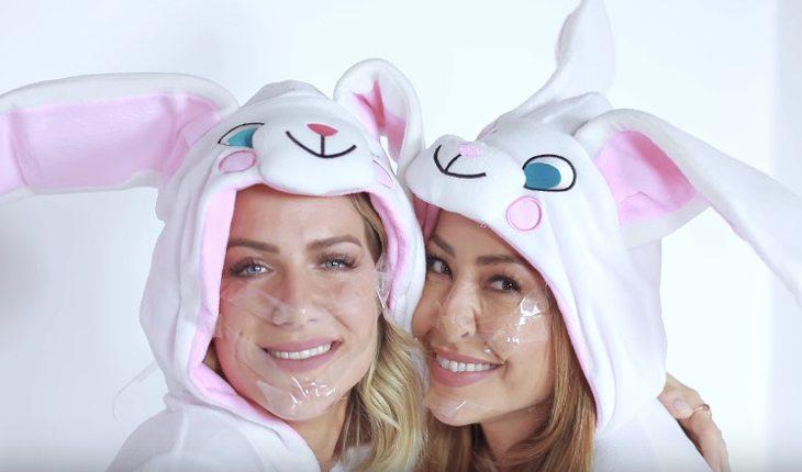 Na foto está a Giovanna Ewbank e a Sabrina Sato em uma cama vestindo roupas de coelho.