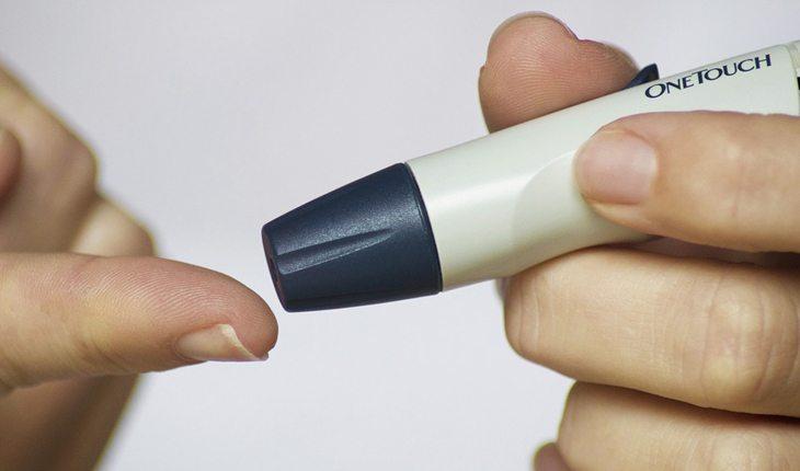 Benefícios da manga. Na foto, um aparelho de medir diabetes e um dedo