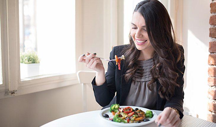 Mitos e Verdades sobre jejum. Na foto, uma mulher olhando uma comida que está em seu garfo