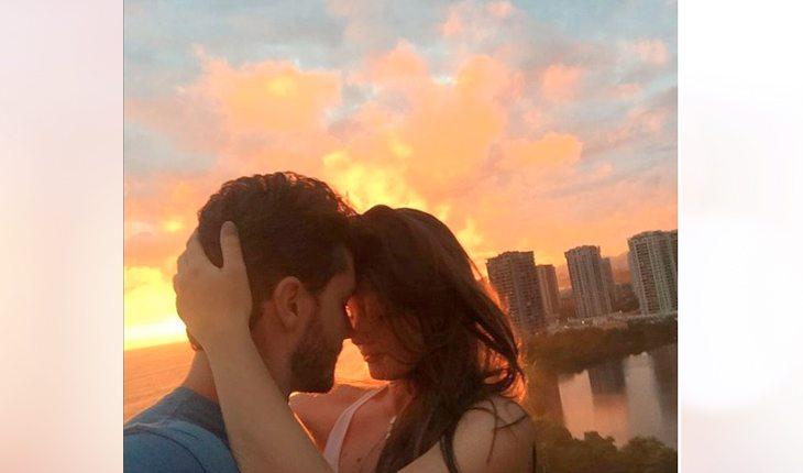 Camila Queiroz e Klebber Toledo se beijando em frente ao pôr do sol