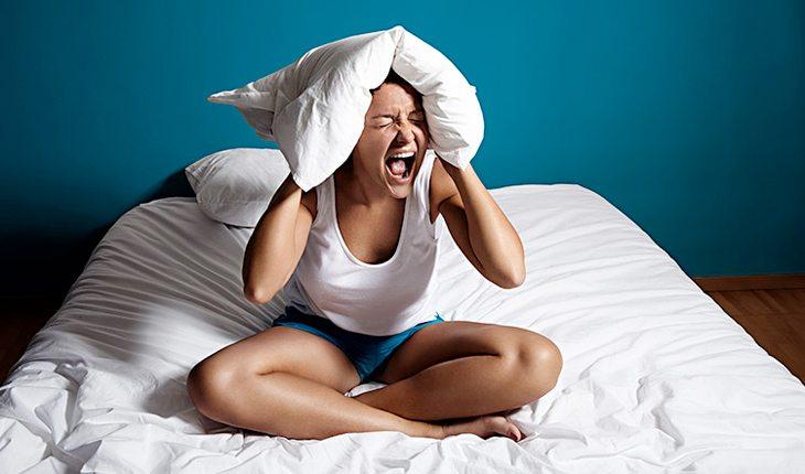 Mitos e Verdades sobre jejum. Na foto, uma mulher gritando com o travesseiro na cabeça