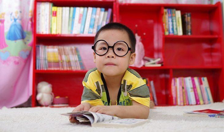 menino com óculos lendo
