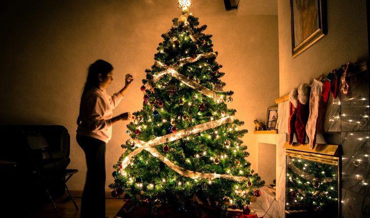 pessoa decorando árvore de natal