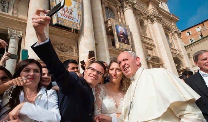 Na imagem, o casal tira uma foto com o papa francisco. Casamento abençoado.