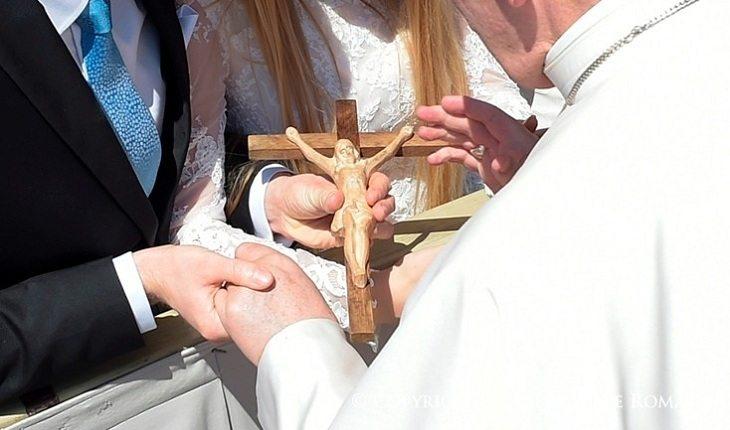 Na imagem, o papa abençoa uma cruz do casal. Casamento abençoado.