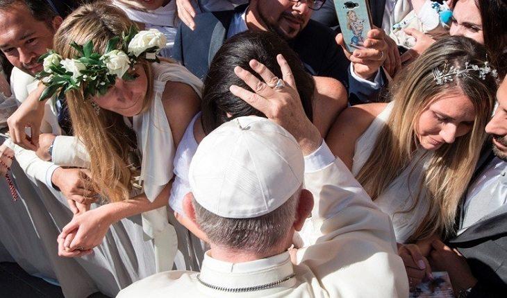 Na imagem, o papa francisco abençoa a noiva, tocando em sua cabeça e rezando. Casamento abençoado.