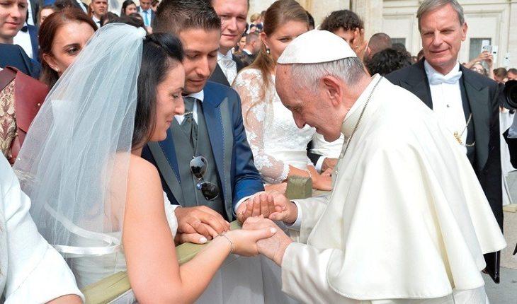 o casal dá as mãos ao papa para rezar. Casamento abençoado.