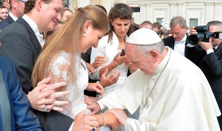 Na imagem, o papa francisco toca na barriga da noiva. Casamento abençoado.