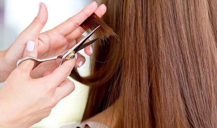 mulher cortando as pontinhas do cabelo com o cabelereiro