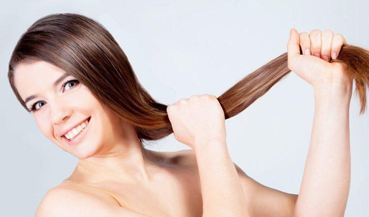 mulher segurando o comprimento do cabelo e puxando