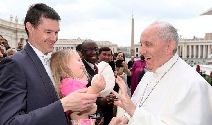 Na image, a menina tira o acessório de cabeça do papa. Fotos mais engraçadas.