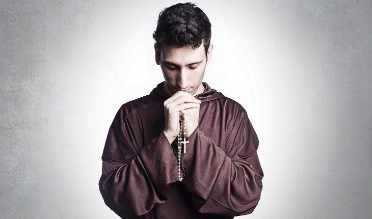 homem rezando segurando terço