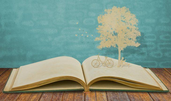 Livro aberto com árvore e bicicleta de papel
