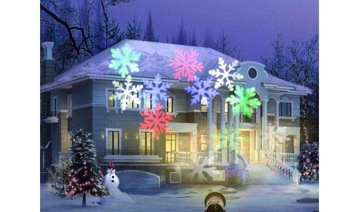 casa com luzes de natal em formato de flocos de neve projetadas na entrada