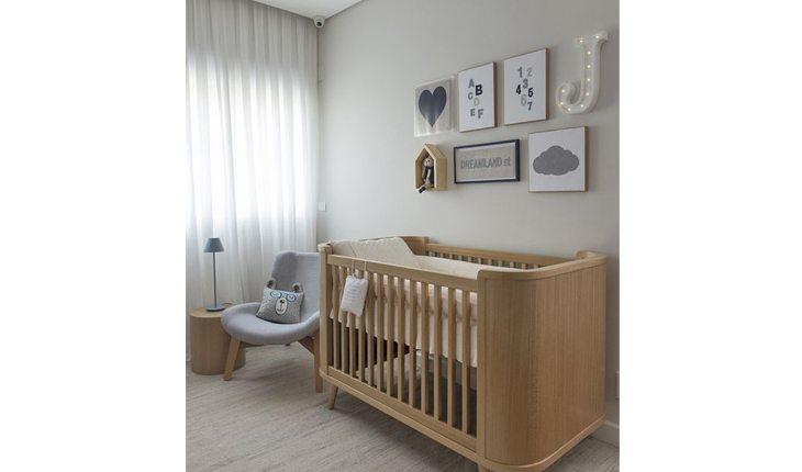 Quarto de bebê para menino nas cores azul, bege e branco com uma cadeira e um berço de madeira