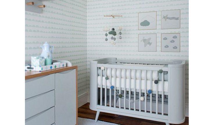 quarto de bebê nas cores branco e azul claro, com a parede listrada e itens em azul mais escuro