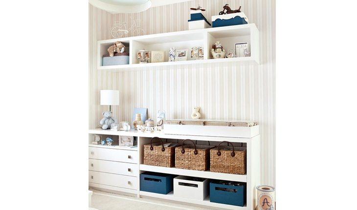 quarto de bebe com moveis em branco, estante e parede e itens em azul