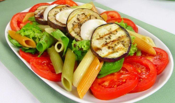 prato de salada com macarrão, tomate, alface e berinjelas por cima