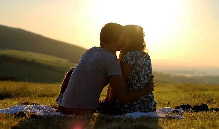 Casal se beijando ao por do sol por terem um amor pleno