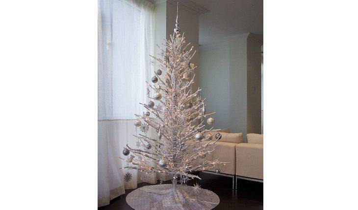 árvore de natal sem folhagens, apens com os galhos brancos, decorada com enfeites prateados
