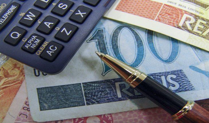Foto de uma calculadora cercada por notas de dinheiro de valores variados