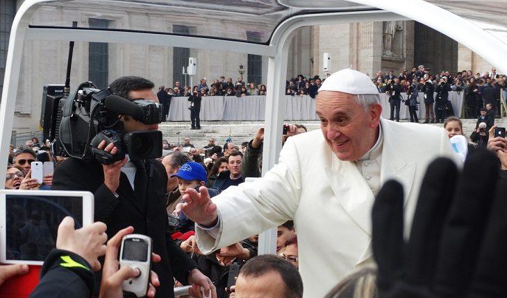 O papa cumprimenta as pessoas com celular. O papa adorado.
