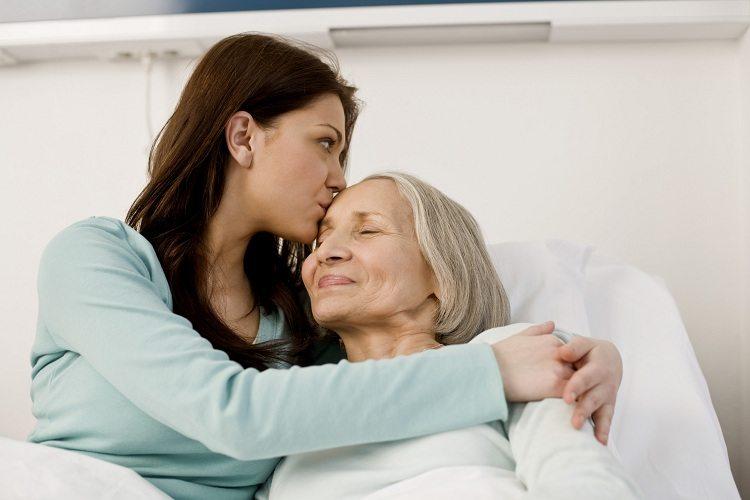 Mulheres na maca de hospital com abraço carinhoso pois São Pelegrino pode ajudar