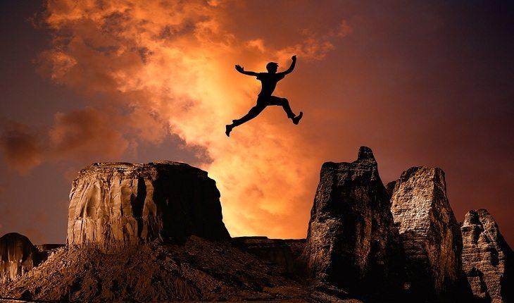 foto de uma pessoa pulando um penhasco, simbolizando superação