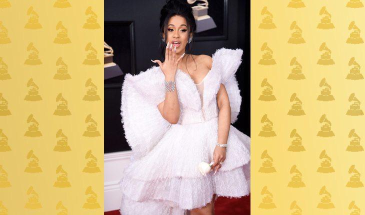 Grammy Awards 2018. Na foto, está a cantora Cardi B com um vestido branco com detalhes plumas