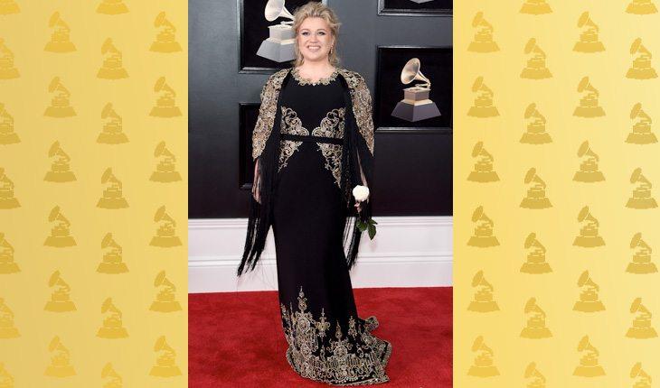 Grammy Awards 2018. Na foto, está a cantora Kelly Clarkson com um vestido preto com detalhes dourado