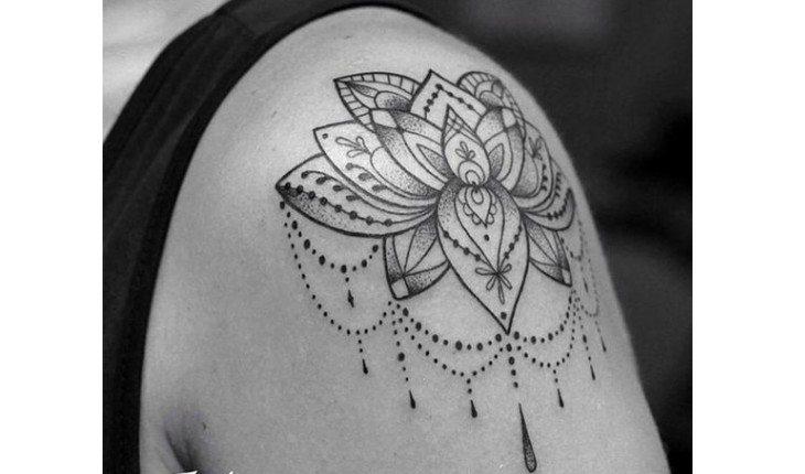 Ombro tatuado com uma flor de lótus