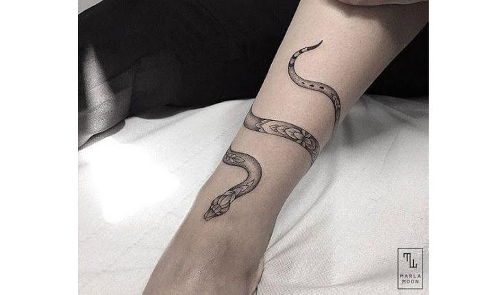tatuagem de cobra dando a volta no braço