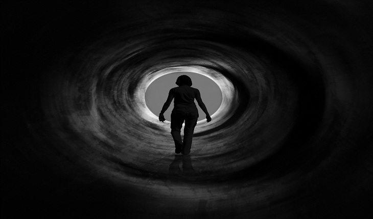 mulher saindo de um túnel escuro