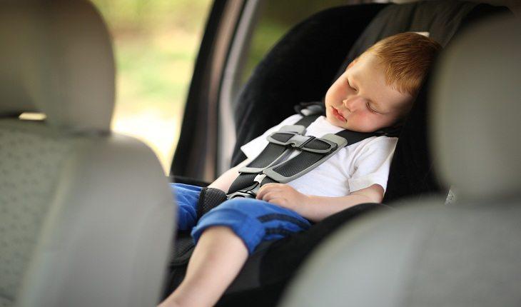 foto de um menino dormindo no carro