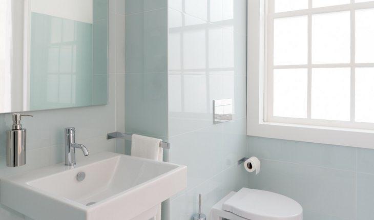 Banheiro azul claro com pia e privada em branco