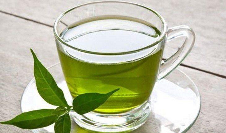 chá verde sendo colocado em uma xícara branca