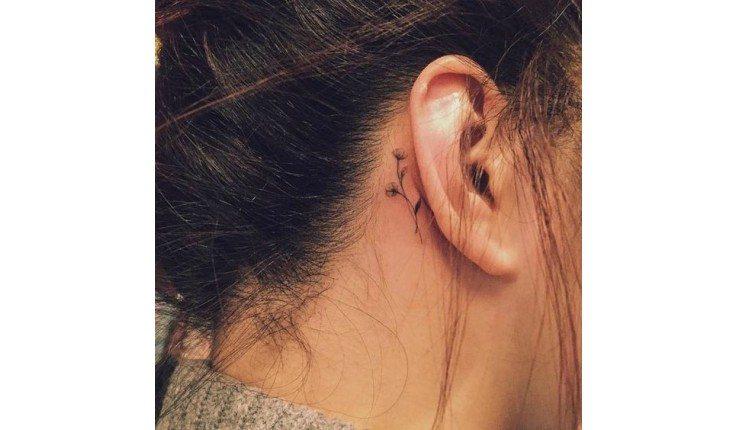 Tatuagem atrás da orelha.