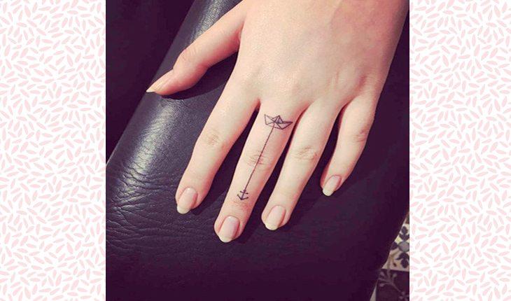 Tatuagens delicadas nas mãos. Na foto, uma mão de uma mulher com uma tatuagem