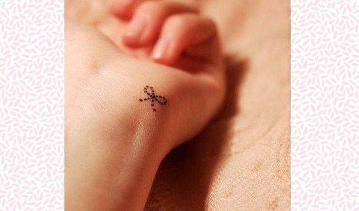 Tatuagens delicadas nas mãos. Na foto, uma mão de uma mulher com uma tatuagem