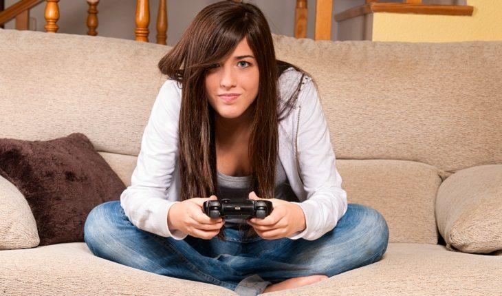 mulher sentada no sofá jogando videogame