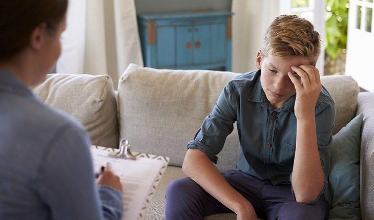 A foto mostra um rapaz fazendo uma consulta com psicoterapeuta