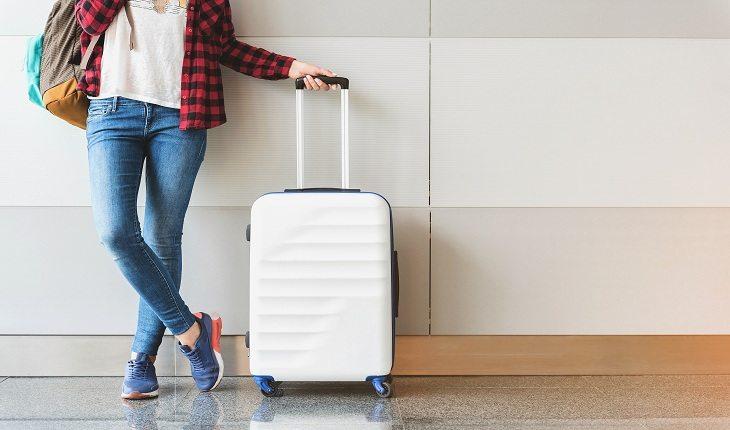 foto de uma mulher carregando uma mala de viagem